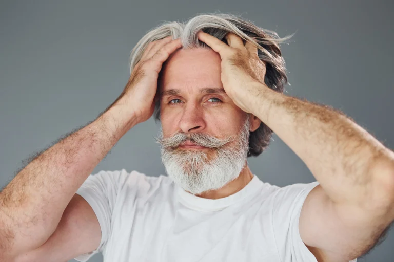 Homme caucasien aux cheveux poivre et sel présentant un résultat naturel