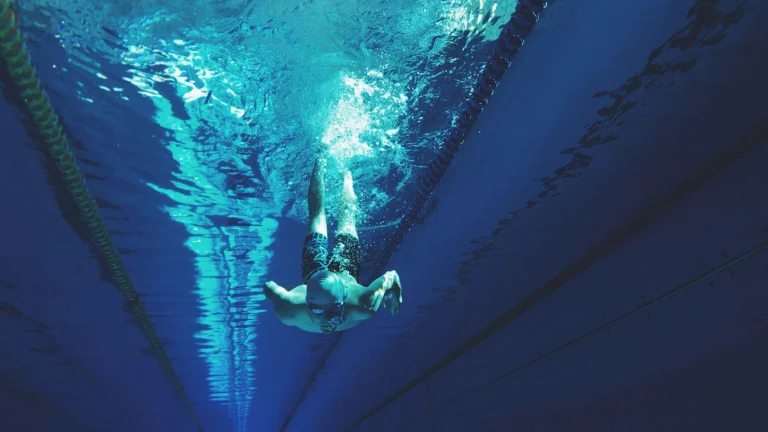 Homme nageant dans une piscine